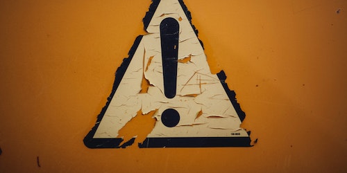 A peeling triangular sign featuring an exclamation mark!